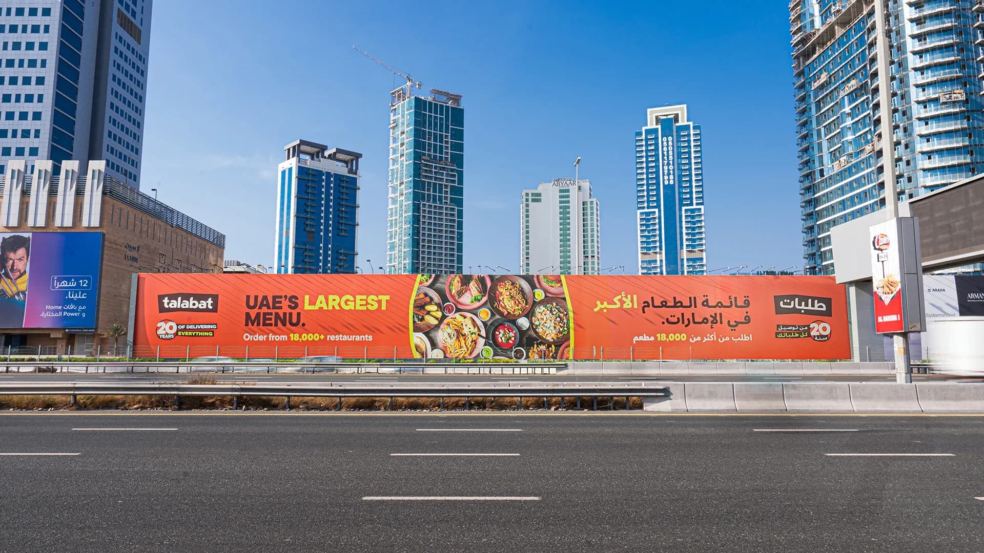 Construction hoarding advertising panel at a Dubai development site, long-term OOH branding