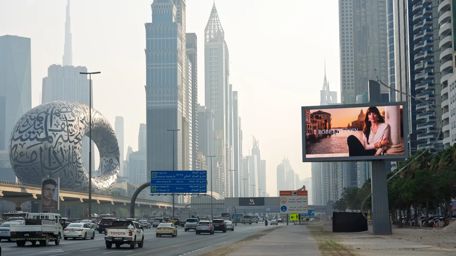 Unipole billboard at a Dubai highway junction, elevated outdoor advertising placement