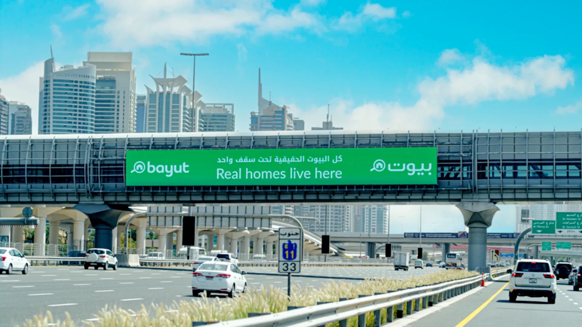 Bridge banner advertising spanning a busy Dubai commuter route, high-impact OOH