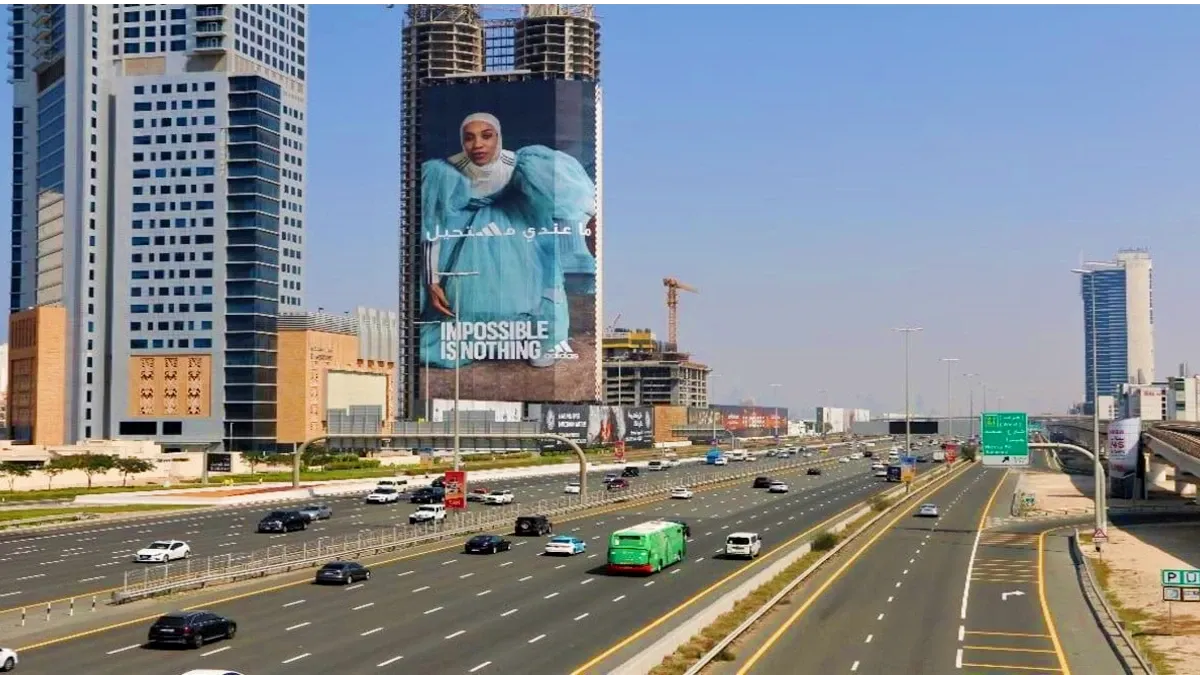 Large building banner on a Dubai high-rise facade, skyline outdoor advertising